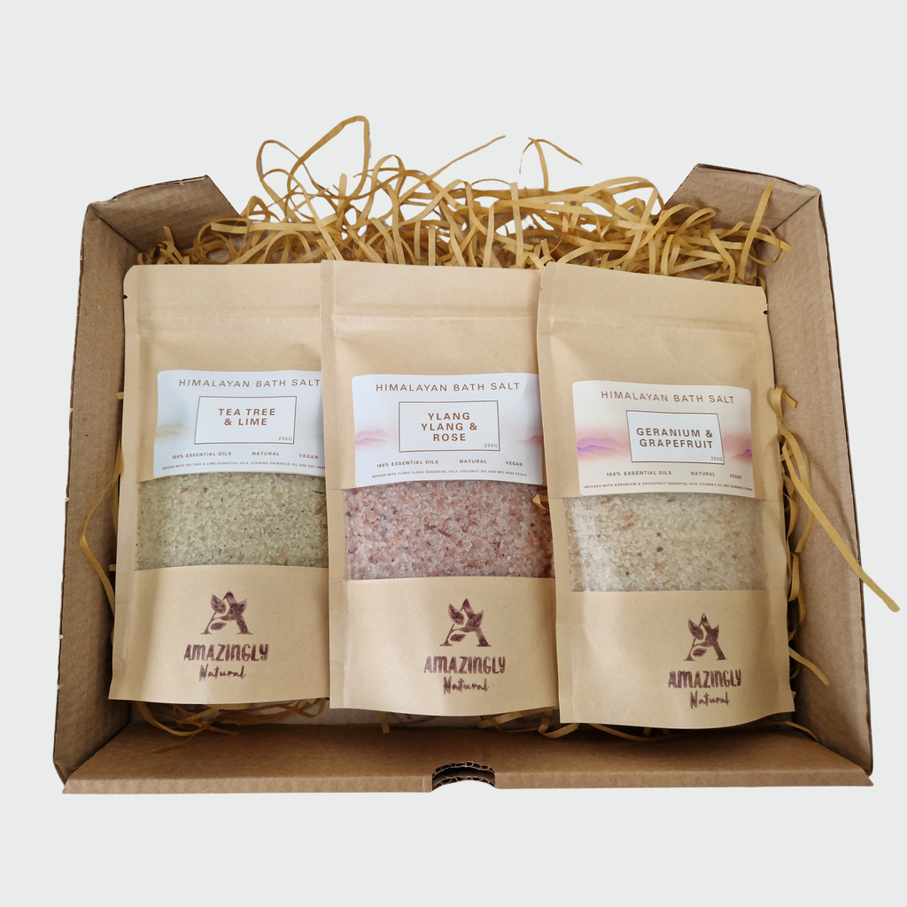 Three bags of Himalayan bath salts in a gift box with decorative straw.