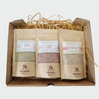 Three bags of Himalayan bath salts in a gift box with decorative straw.