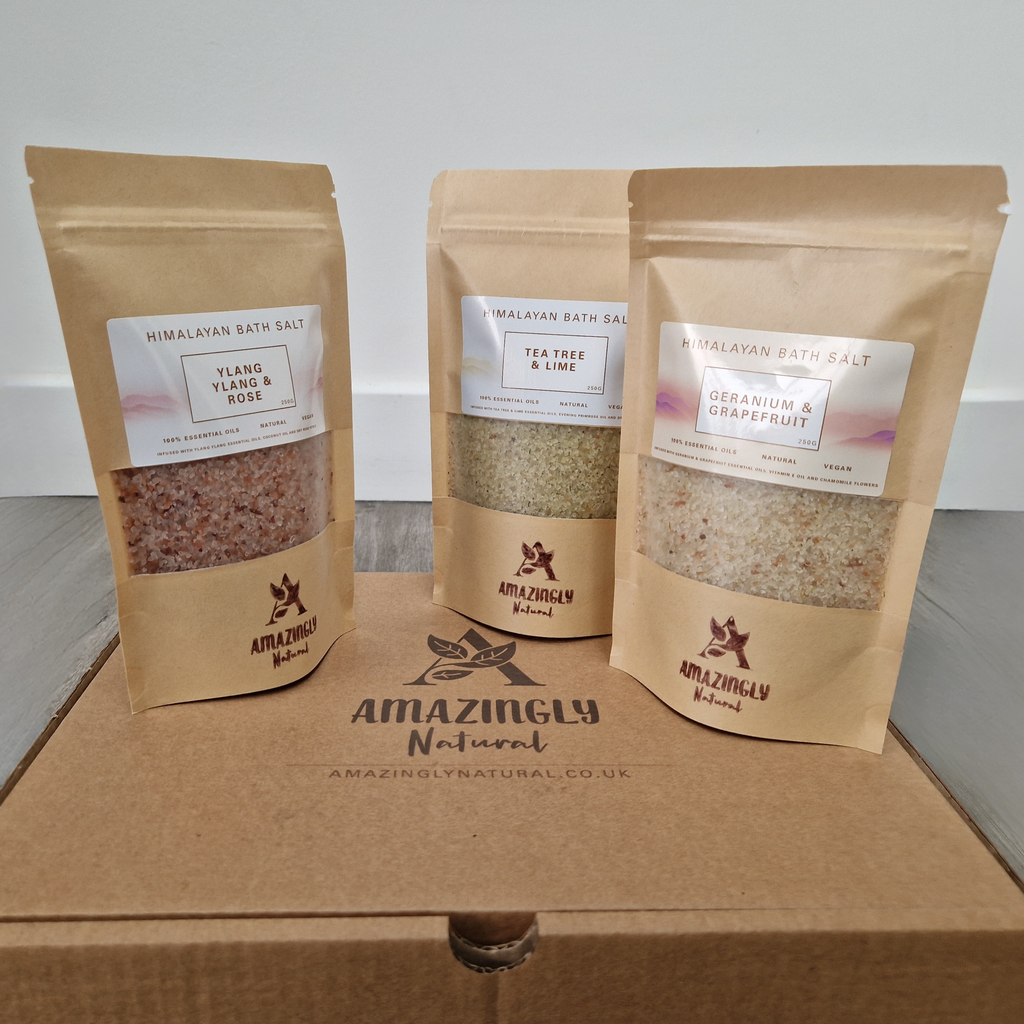 Three packages of Himalayan bath salt from Amazingly Natural on a gift box.
