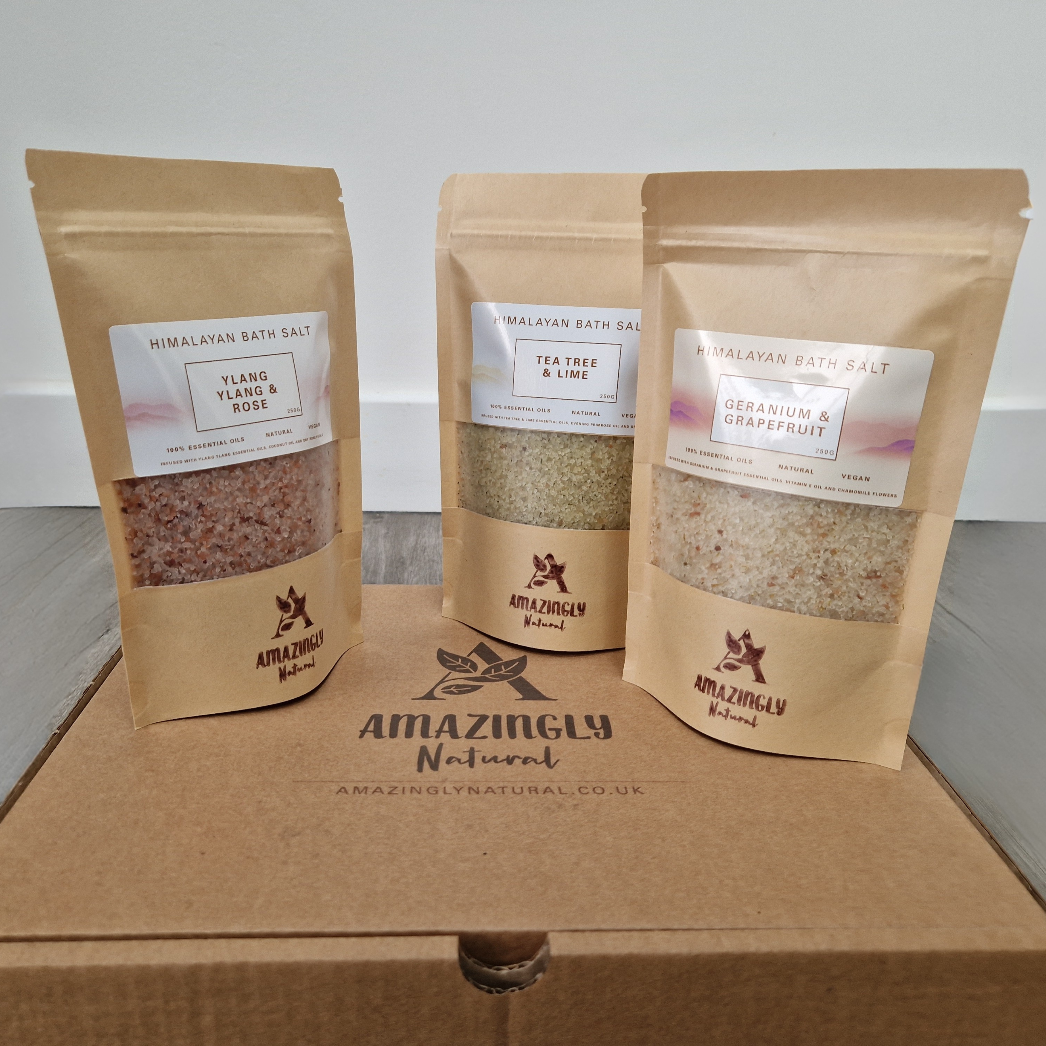Three packages of Himalayan bath salt from Amazingly Natural on a gift box.