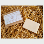 Natural handmade soap bar and packaging on a bed of straw