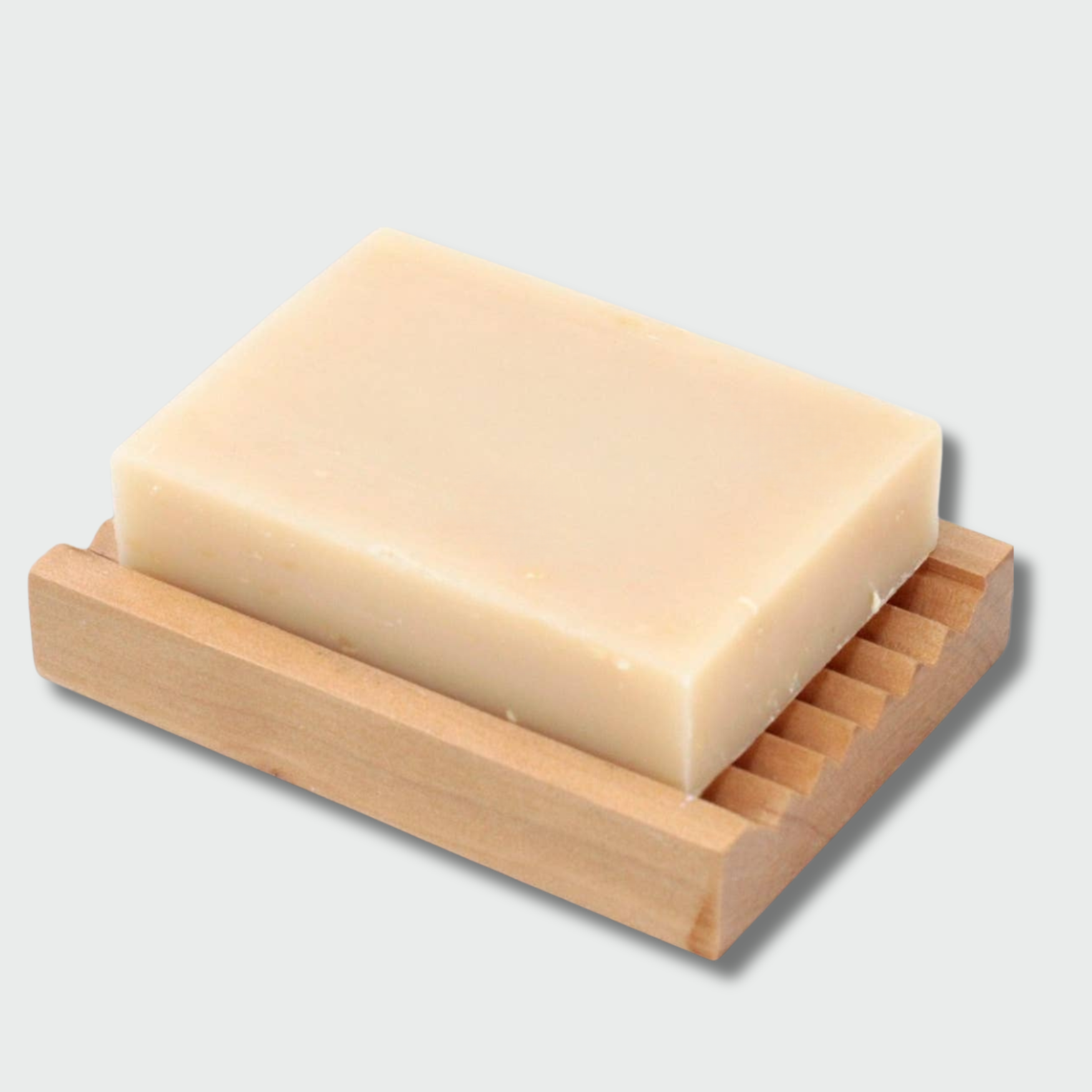 Bar of soap on a wooden soap dish against a light gray background