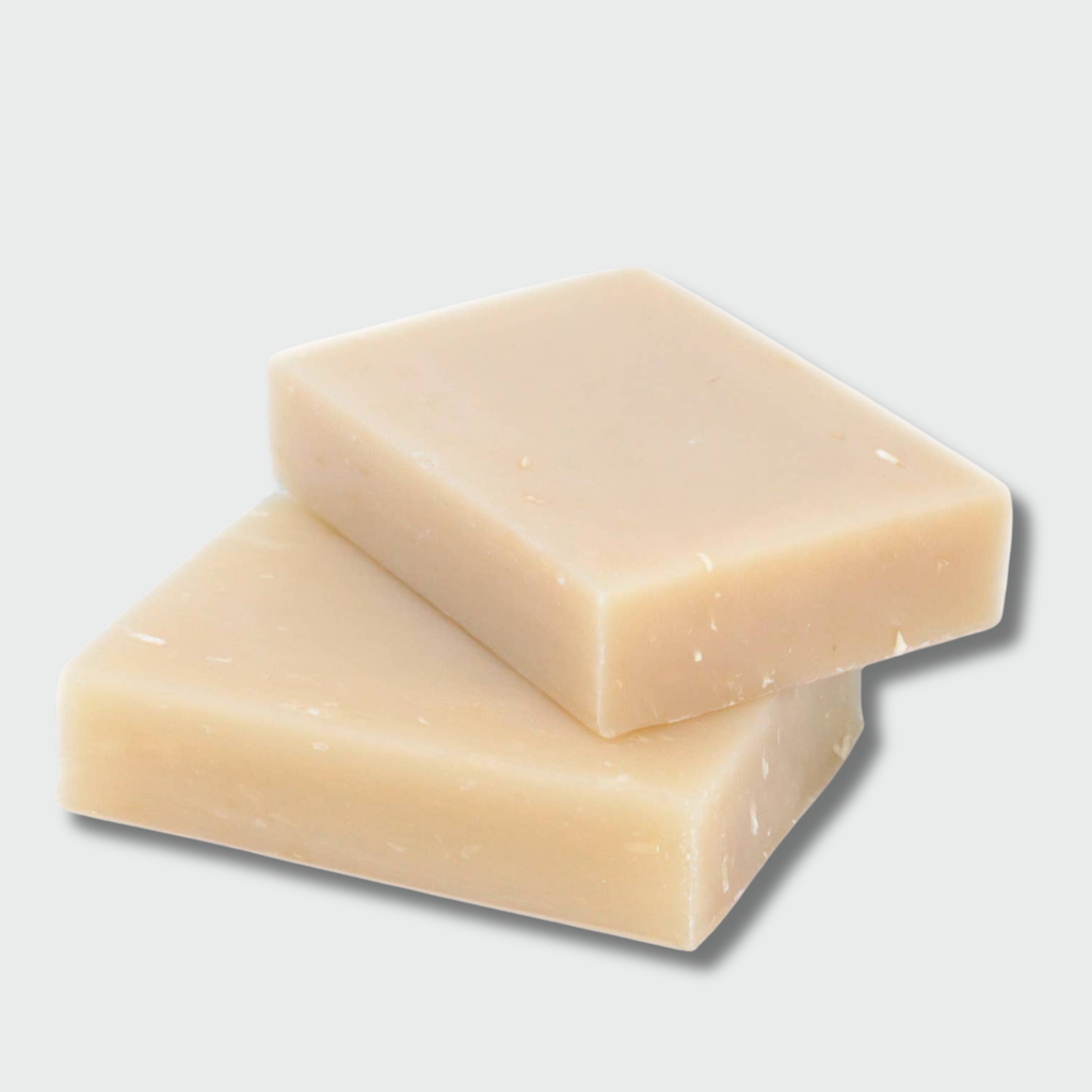 Two beige coconut soap bars stacked on a light gray background