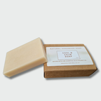 Bar of soap with a brown box on a light gray background. Amazingly Natural